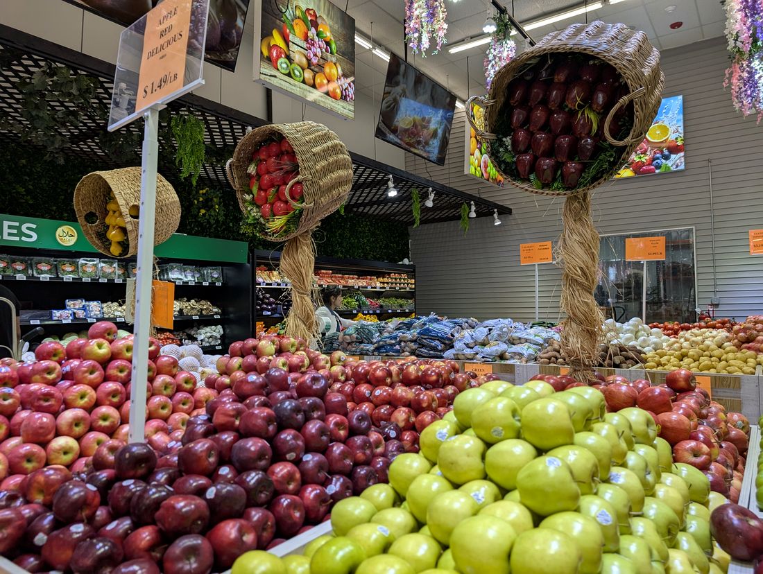 Apples under the hanging wicker baskets in the ASR Food Market produce aisle.