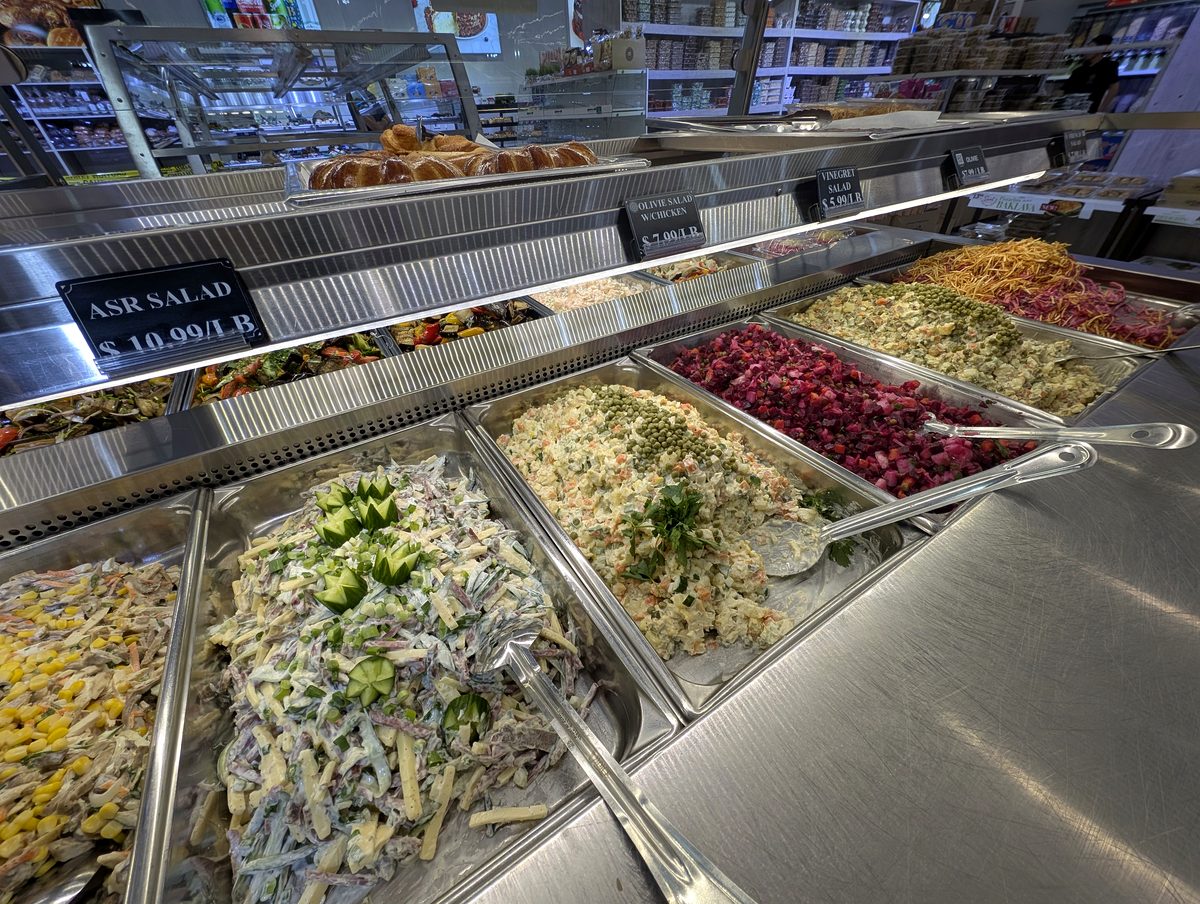 Self-service salad bar of many stainless bins at ASR Food Market.