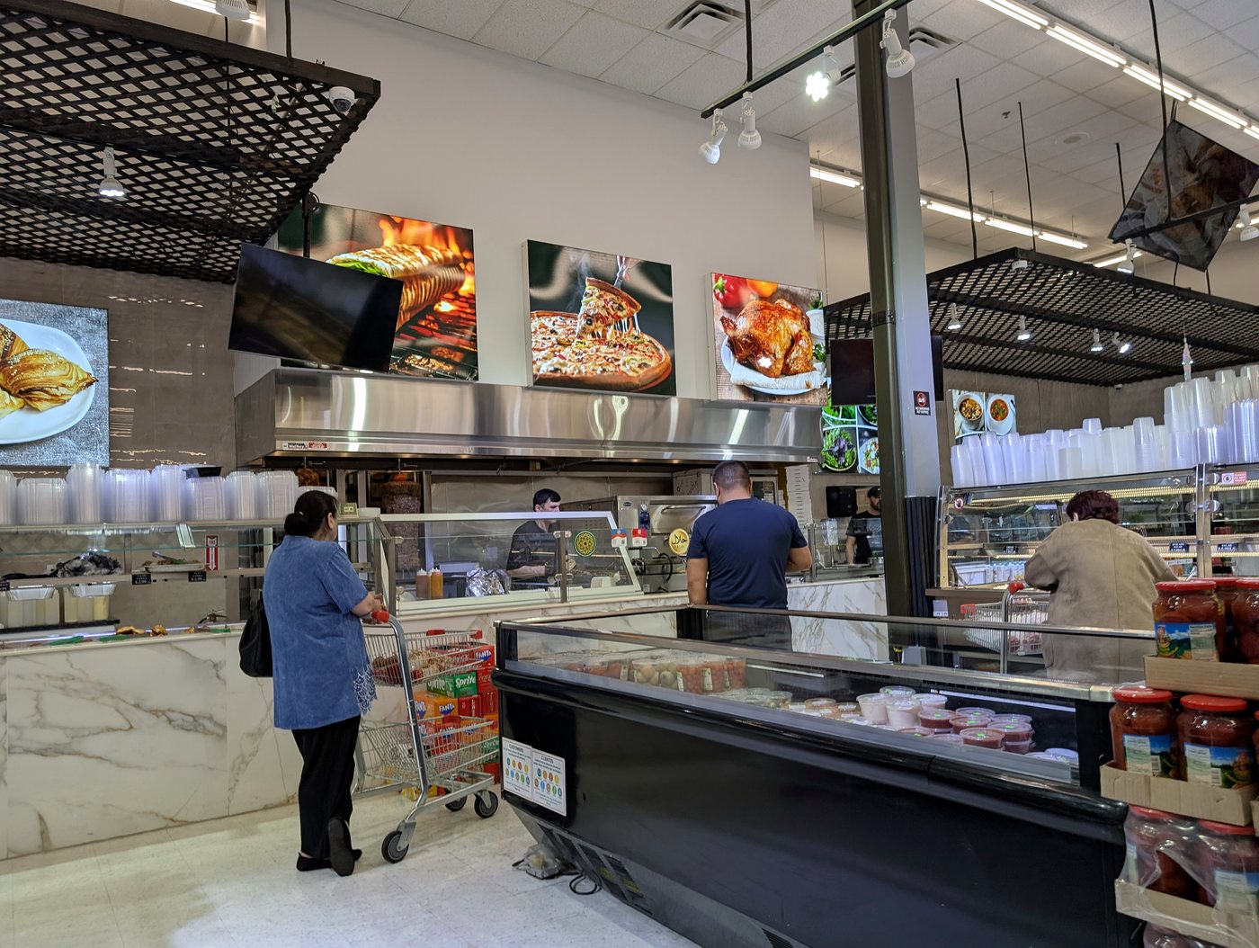 Service counter with menu boards and staff at ASR Food Market.